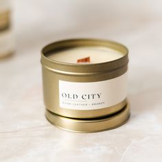 an old city candle is sitting on a white countertop next to some other items