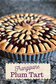 a close up of a pie on a table with the words frangane plum tart