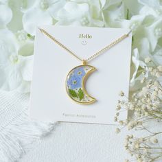 Welcome to my shop! Nice to meet you:) ⭐Product feature: * Pendant Size :27 mm(width), 31 mm(length) * Length of Necklace: 14-20 in ❀ This moon necklace are handmade and made with pressed Forget me Not flower and resin.  ❀These flowers symbolise love and respect, so they make the perfect gift idea for  Mother's Day, birthdays, anniversaries or valentines day. ❀Due to the handmade nature of this product, slight variations may occur, however, the design remains as similar as possible. ⭐Product Service: ❀ Well packaged: You can choose simple packaging or gift box packaging. ❀Write greeting cards for free: Maybe you are choosing a special gift for your sister, female friend, girlfriend, family, lover, daughter, wife and mother for birthday, anniversary, Mother's Day or other special days.  We Green Botanical Necklace For Gift, Green Botanical Necklace For Gifts, Elegant Birth Flower Resin Jewelry, Delicate Resin Jewelry With Birth Flower, Gold Resin Necklace With Birth Flower, Mother's Day Pendant With Pressed Flowers Necklace, Green Round Necklaces With Pressed Flowers, Mother's Day Pressed Flower Pendant Necklace, Green Pressed Flower Round Pendant Jewelry