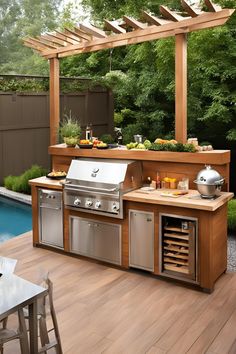 an outdoor kitchen with stainless steel appliances and grilling area next to a swimming pool