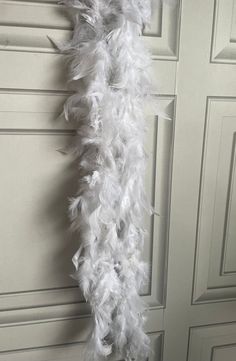 a white feather garland hanging on a door