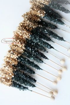 several toothpicks with gold and black glitter on them