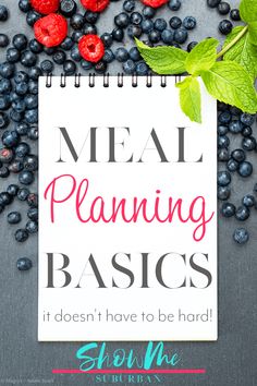 a notepad with the words meal planning basics on it next to berries and leaves