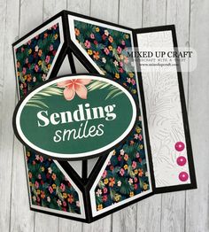 an open card with the words sending smiles on it and some flowers in front of it