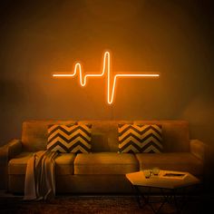 a living room with a couch and a neon heartbeat sign on the wall above it