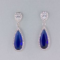 "Would you love to sparkle even brighter on your special day? Looking for your something Blue? Gorgeous bridal earrings have been created using a long sapphire blue crystal in a cz halo and are completed by your choice of earpost. Perfect for the Mother of the bride. Style #1~ Art Deco-inspired earpost. CZ crystals studded in a double swirl. Style #2~ Teardrop Earpost -pearl CZ crystal in a halo of smaller crystals. Post back Style #3~ Smaller Teardrop earpost, inverted pear crystal with a halo Blue Pear-shaped Party Earrings, Blue Pear-shaped Teardrop Earrings For Formal Occasions, Blue Sapphire Pear-shaped Earrings, Blue Sapphire Earrings With Sparkling Stones, Blue Drop Jewelry For Wedding, Blue Drop Bridal Earrings For Formal Events, Blue Drop Bridal Earrings For Formal Occasions, Sapphire Teardrop Earrings For Wedding, Blue Cubic Zirconia Teardrop Earrings