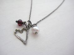 "A sweet little hammered sterling silver heart charm, a tiny faceted garnet and a freshwater pearl are suspended from a dainty sterling silver cable chain. Length 18\" Heart Charm: 11.5mm x 10mm Garnet: 4mm Pearl: 5mm Sterling silver is oxidized and hand polished for a rustic finish. Thanks for looking! Nancy" Oxidized Silver Bracelet, Oxidized Silver Necklace, Pearl Charm Necklace, Crystal Pearl Earrings, Dainty Gold Bracelet, Heart Charm Necklace, Sterling Silver Heart Necklace, Gold Coin Necklace, Sterling Silver Heart Pendant