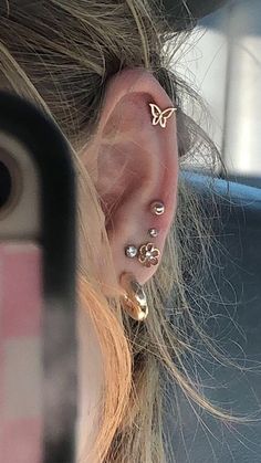 a woman's ear with three piercings on it