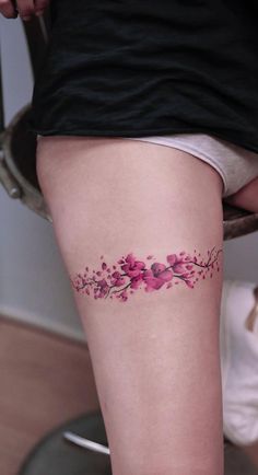 a woman's thigh with pink flowers on it