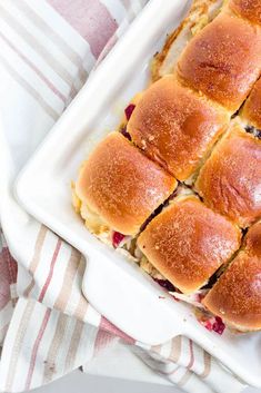 a white plate topped with rolls covered in cheese and jelly on top of a table