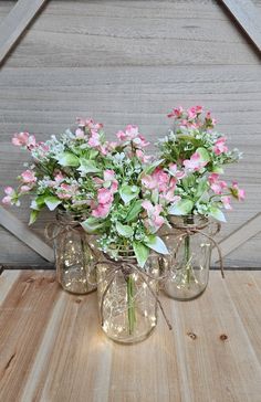 three mason jars filled with pink and white flowers