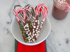 some candy canes are in a white bowl