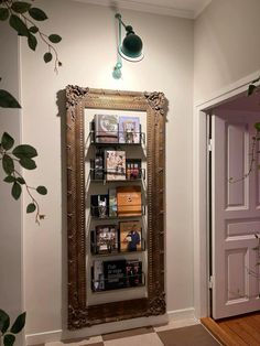 there is a large mirror on the wall next to a shelf with books and magazines