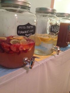 mason jars filled with liquid and fruit on a table