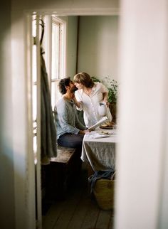 two people sitting at a table in front of a window