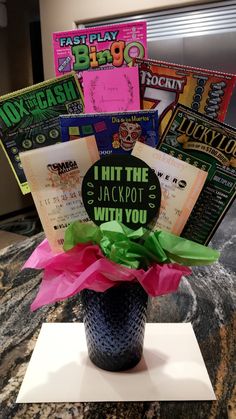 a vase filled with lots of different types of cards and paper on top of a table