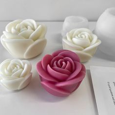 three white and pink flowers sitting next to each other on top of a countertop