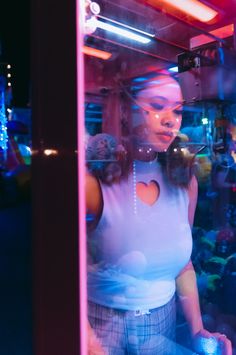 a woman standing in front of a glass window