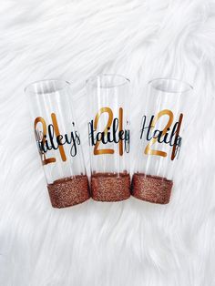 three personalized tumblers are sitting on a white furnishing with gold glitter