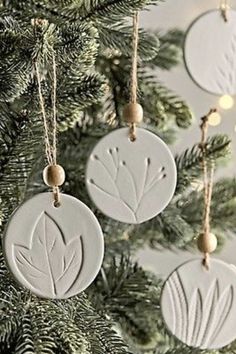 three ceramic ornaments hanging from a christmas tree