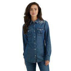 No Western wardrobe would be complete without a classic snap shirt. Combining the 100% cotton denim you love with the clean and simple silhouette you can always depend on, the women's Wrangler Retro snap denim shirt offers up vintage cowgirl style with some contemporary attitude. This long-sleeve snap shirt comes with many of the iconic Wrangler details you look for as signs of superior quality, including Western front and back yokes with embroidery and genuine pearl snaps as well as snap flap p Western Style Relaxed Fit Medium Wash Tops, Western Style Denim Blue Shirt For Rodeo, Fitted Denim Tops For Ranch, Medium Wash Cotton Western Shirt, Western Style Denim Blue Cotton Tops, Fitted Denim Blue Western Top, Western Style Denim Blue Button-up Tops, Denim Blue Western Button-up Tops, Western Denim Shirt With Button Closure