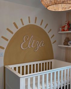 a baby's room with a white crib and yellow sun decal on the wall