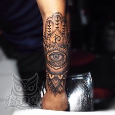 a person with a hamsa tattoo on their arm