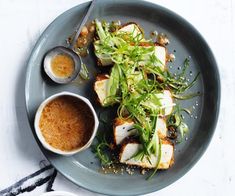 a plate that has some kind of food on it with sauces and spoons