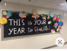 this is your year to sparkle bulletin board on the wall in an empty room with balloons and streamers