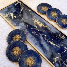 three blue flowers sitting on top of a white towel next to some gold flakes