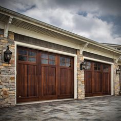 two brown garage doors on the side of a house