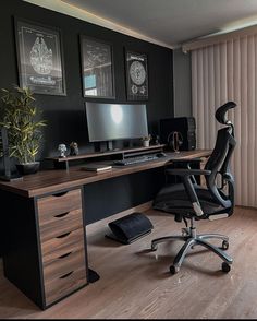 a desk with a chair and computer on it in front of a window that has vertical blinds