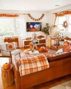 a living room filled with lots of furniture next to a window covered in fall decorations