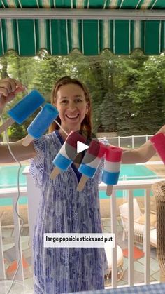 a woman standing on a porch with her hands in the air and holding up some pieces of paper