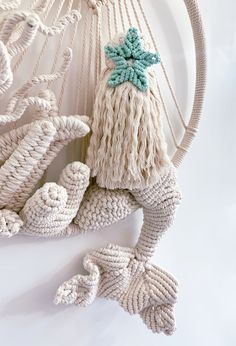 a white plate topped with knitted items on top of a wooden table next to rope