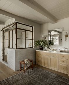 a bathroom with two sinks and a shower in the corner, along with a rug on the floor