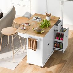 a kitchen island with two stools next to it and some food on the counter