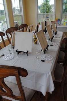 a long table is set up with place settings for the guests to sit down at