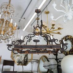 a chandelier hanging from the ceiling in a room filled with furniture and decor