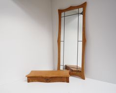 a mirror sitting on top of a white counter next to a wooden box with a drawer