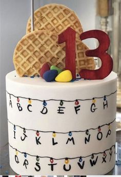 a birthday cake with the number thirteen on it and a waffle - shaped cookie