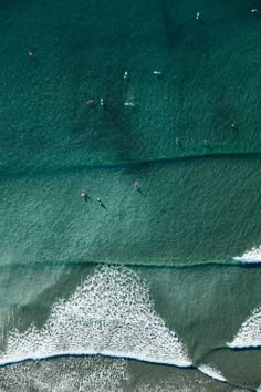 two surfers are riding the waves in the blue ocean, top view from above