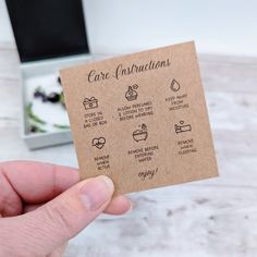 a person holding up a card with instructions for care instructions on it in front of a desk