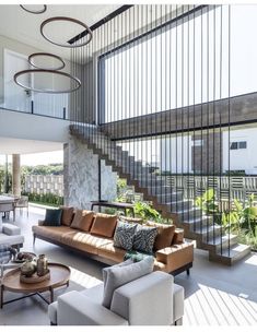 a living room filled with furniture next to a spiral stair case in front of a large window