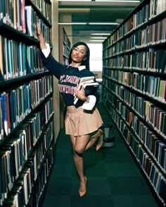 a woman is running through a library full of books