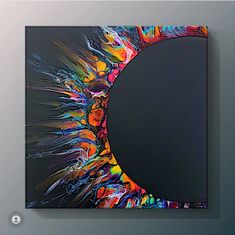 an abstract painting on a wall with a circular hole in the center and colorful paint splatters all over it