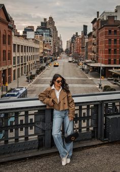 a woman leaning on a rail in the middle of a city