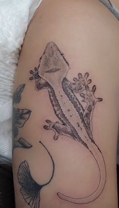 a lizard tattoo on the back of a woman's arm