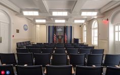 an empty meeting room with chairs and a podium