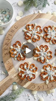 a wooden board topped with pretzels on top of a white table next to christmas decorations